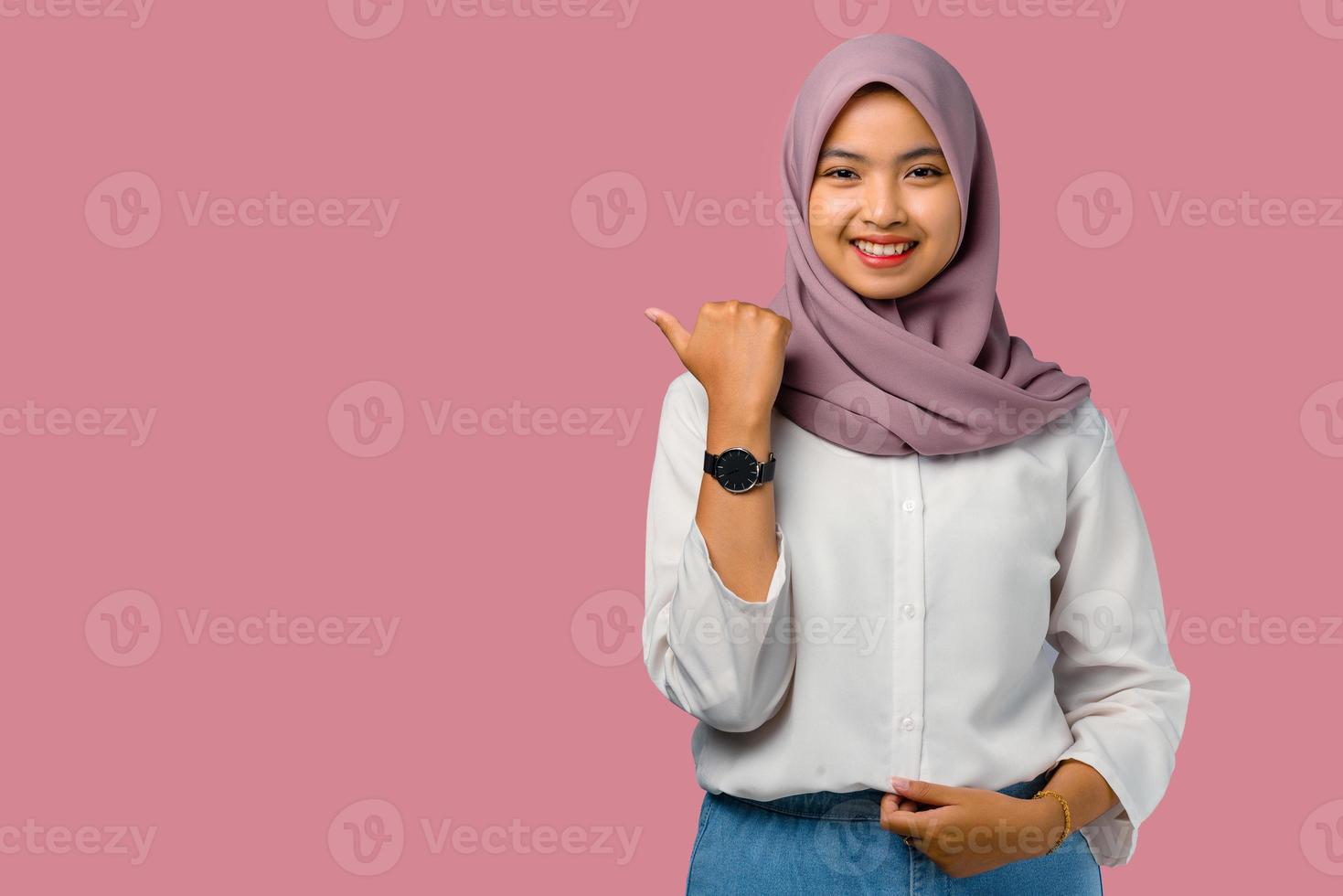 Frau, die einen Hijab auf einem rosa Hintergrund trägt foto