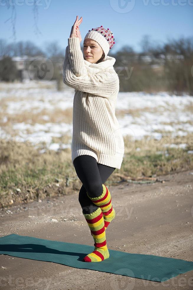 Eine junge sportliche Frau führt Yoga und Meditationsübungen im Freien durch foto