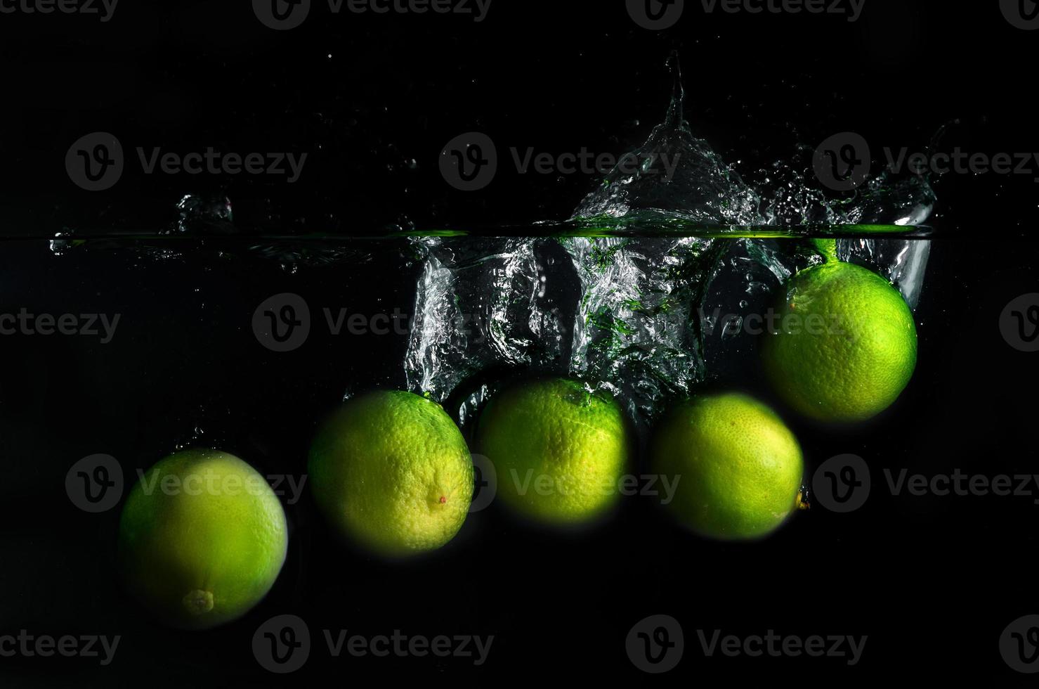 Grün Zitronen im das Wasser foto