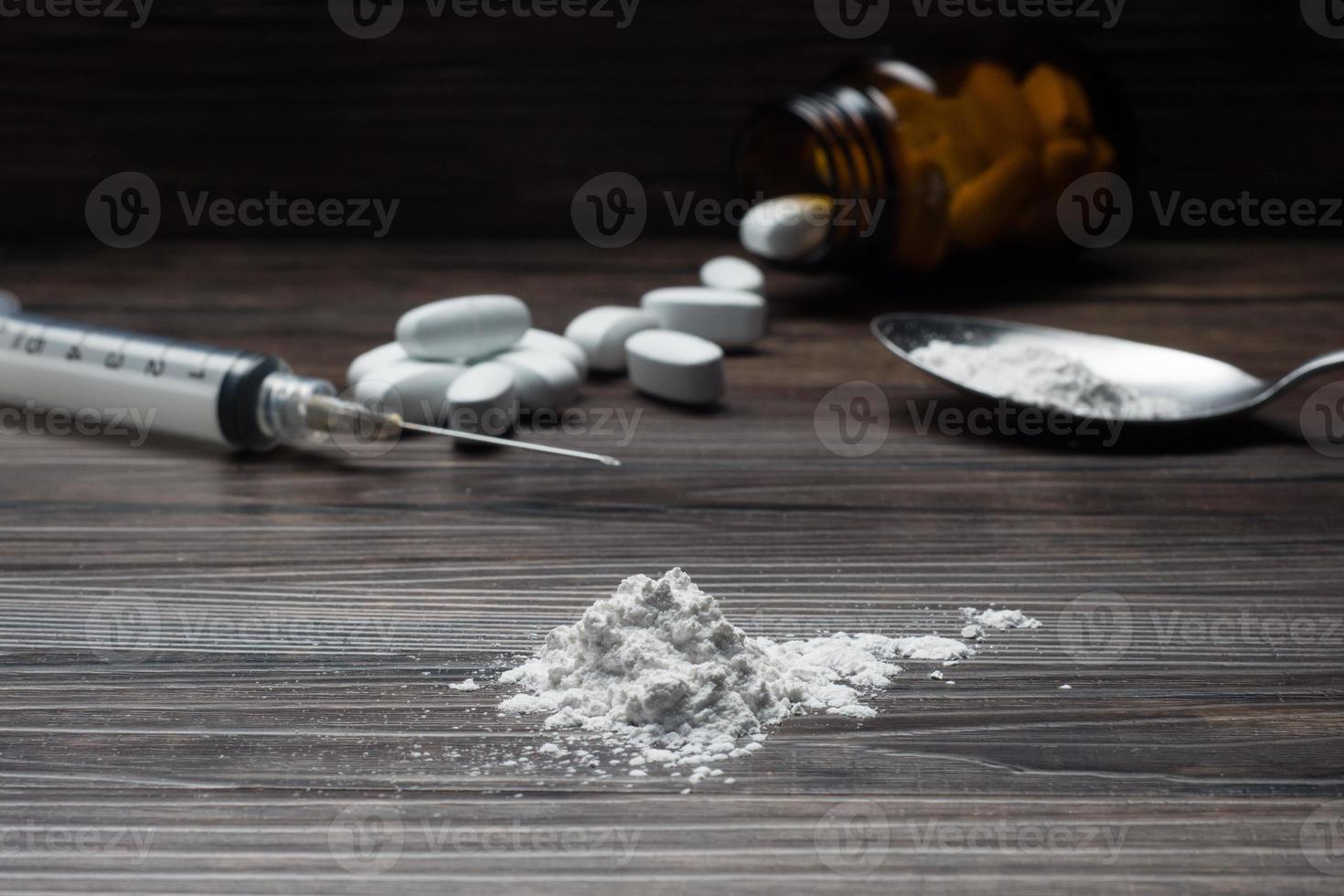 Drogen einstellen - - Pulver und Tabletten und Spritze auf hölzern Hintergrund foto