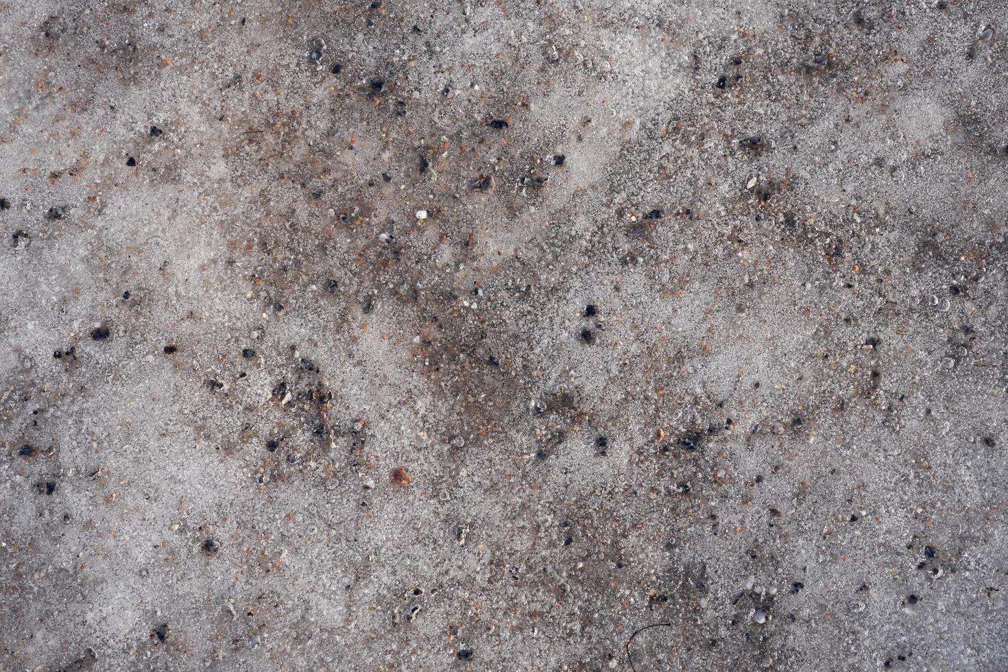geschmolzenes schmutziges Eis mit strukturiertem Hintergrund der Granitkrume foto