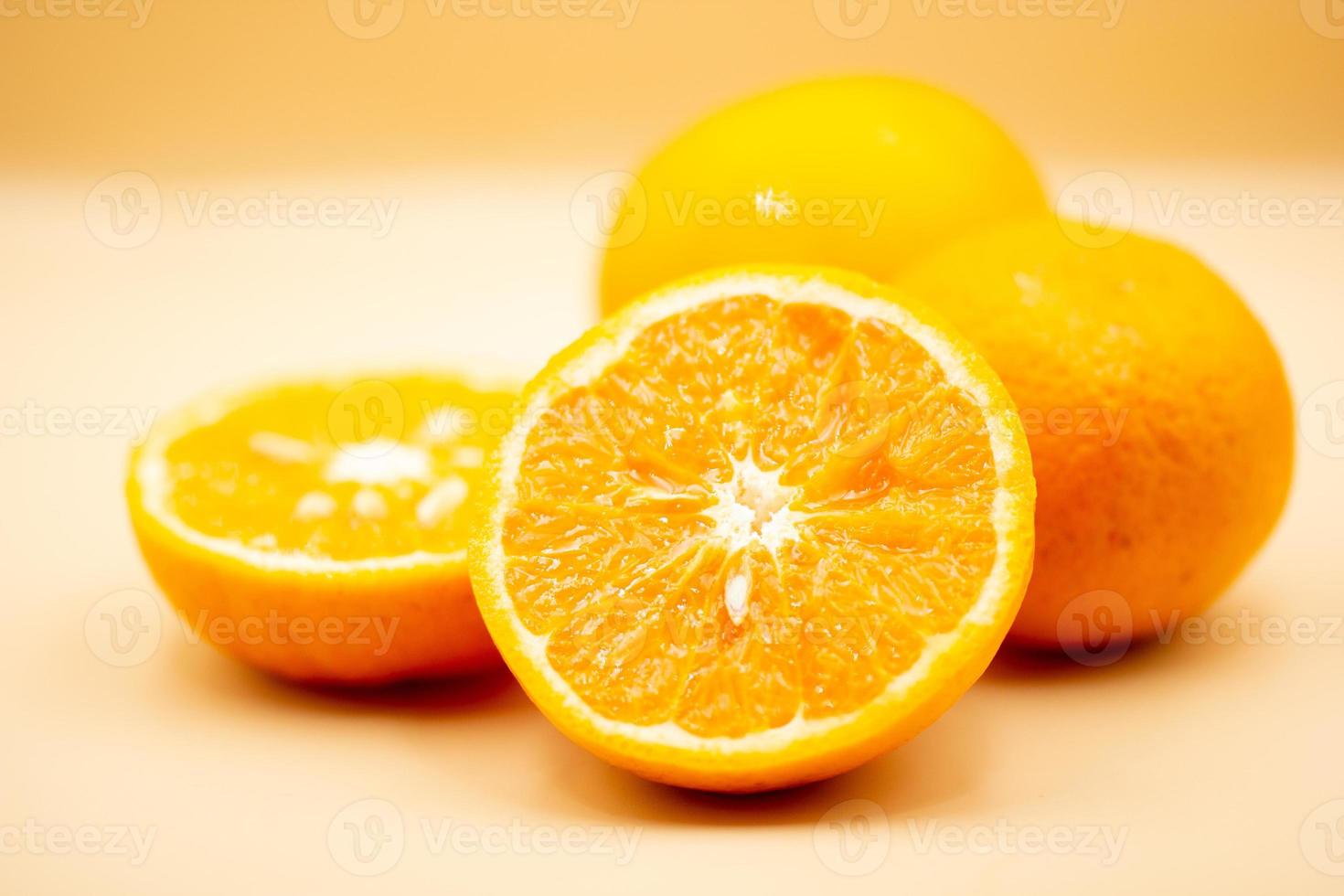 Orangen auf Rosa Hintergrund. einer Orange ist Schnitt im Hälfte, das andere ist ganz. foto