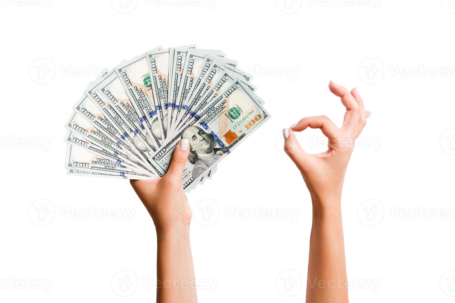 isoliert Bild von Dollar im einer Hand und zeigen okay Geste mit Ein weiterer Hand. oben Aussicht von Geschäft Konzept foto