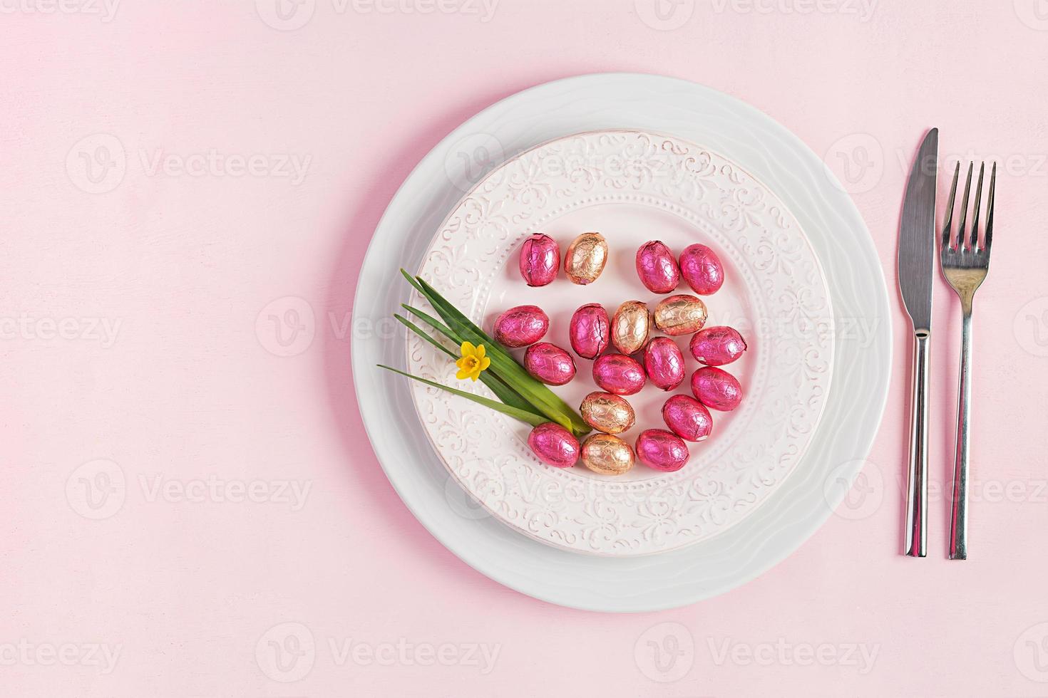 glücklich Ostern. Tabelle Rahmen zum Ostern Urlaub. Ostern Eier, Blume und Besteck auf Rosa Hintergrund. oben Sicht, eben legen foto