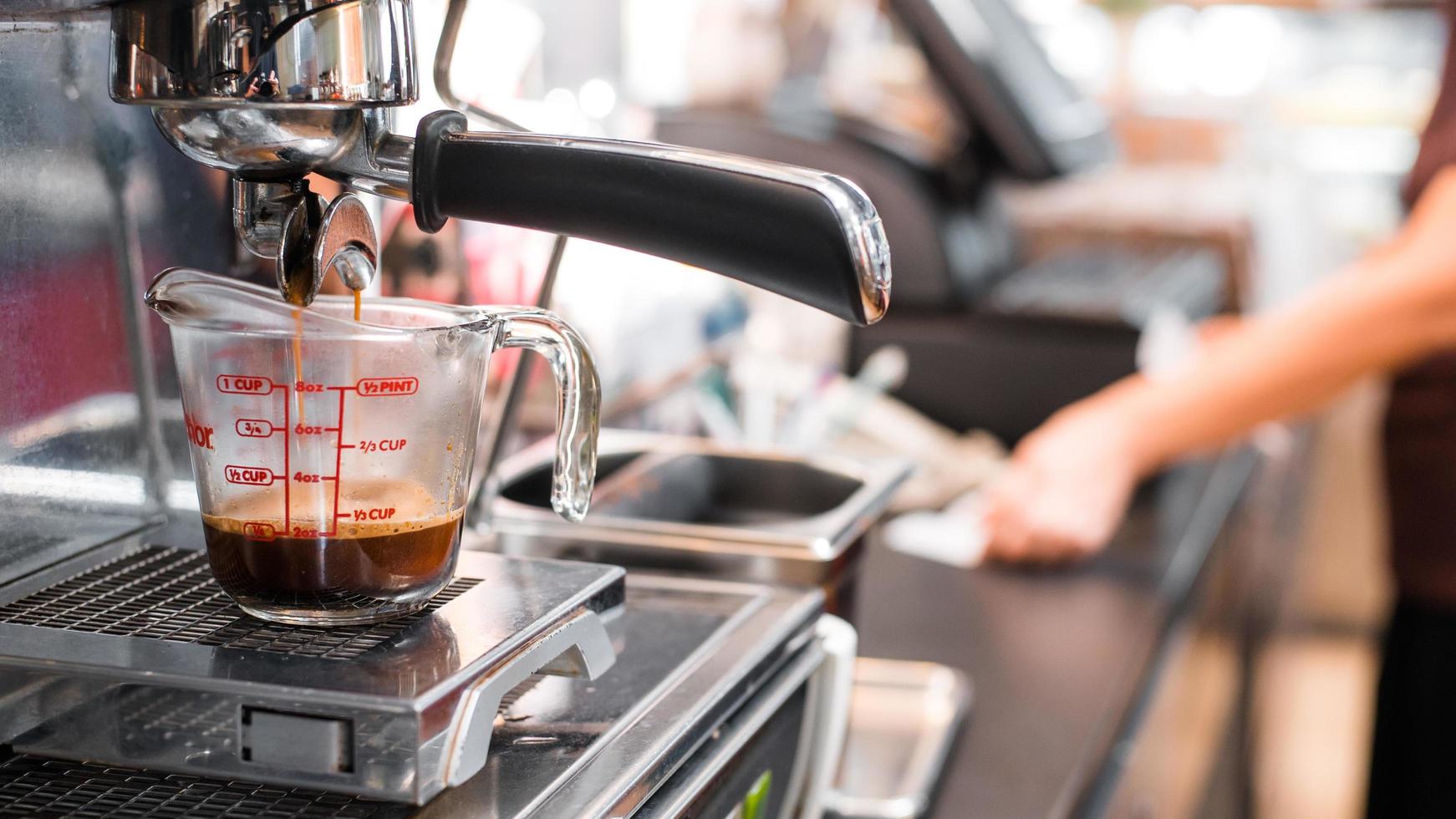 Espresso wird in einen Messbecher gegossen foto