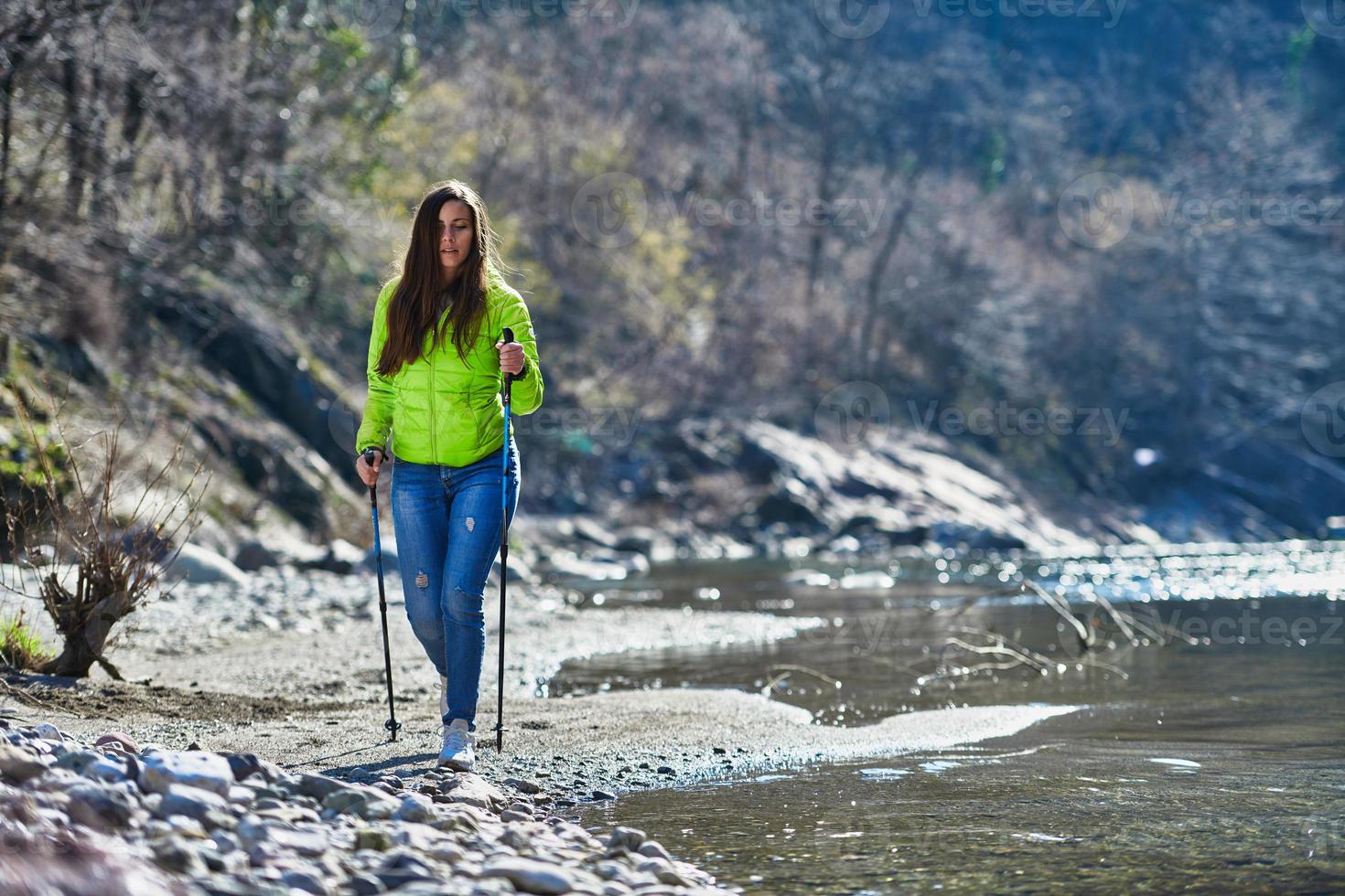 junge Frau, die auf einer Flussgrenze wandert foto