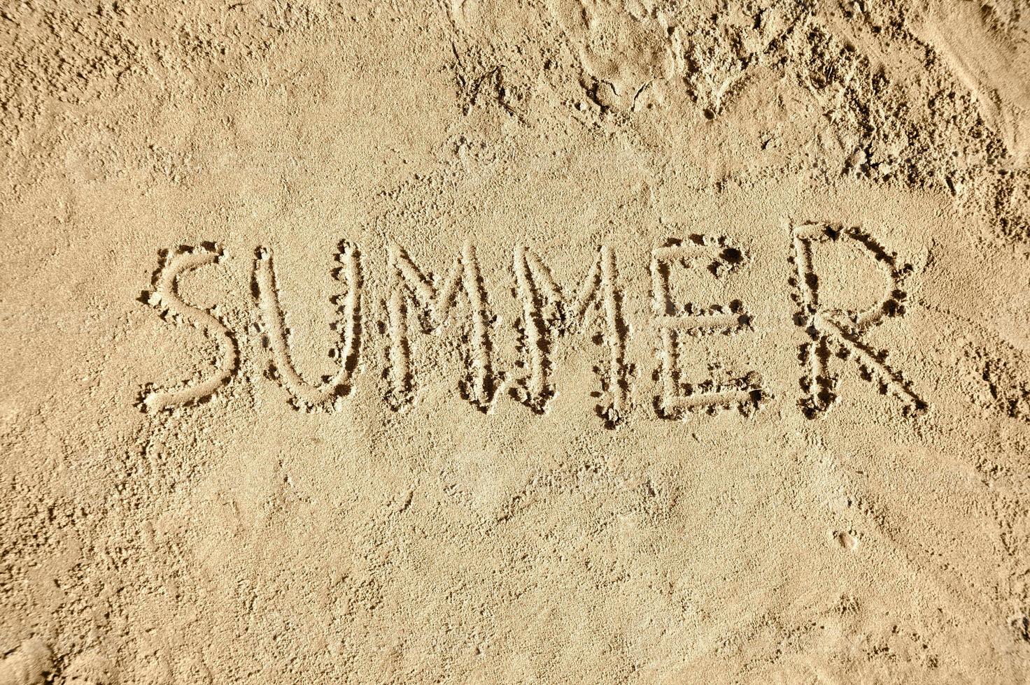 Sommer- Wort handgeschrieben auf Sand foto