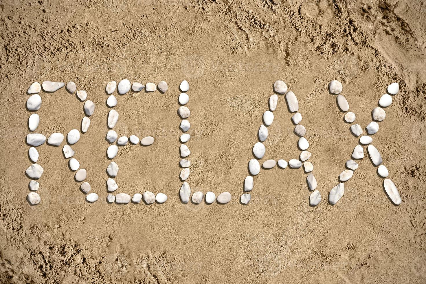 entspannen - - Wort gemacht mit Steine auf Sand foto