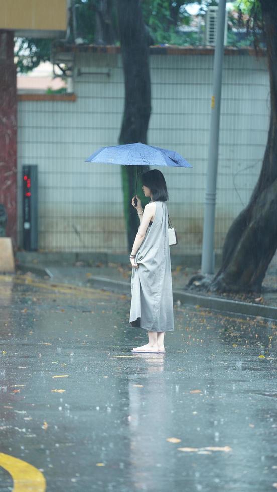 Guangzhou Stadt, China, 2022 - - das Menschen Gehen mit Regenschirm im das regnerisch Tag foto