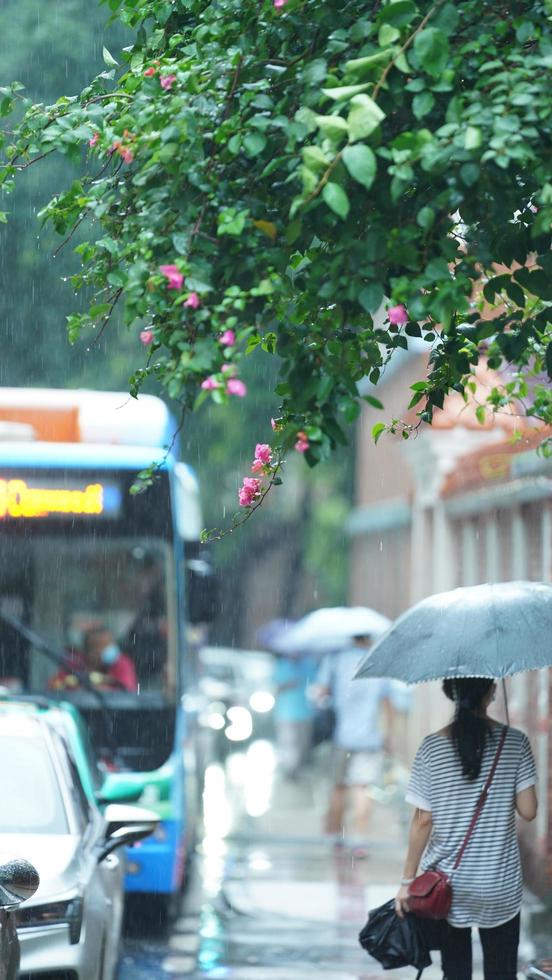 Guangzhou Stadt, China, 2022 - - das Menschen Gehen auf das Straße mit das Regenschirm im das regnerisch Tag foto