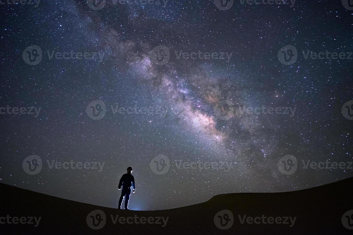 Milchstraßengalaxie mit einem Mann, der an der Teerwüste, Jaisalmer, Indien steht und beobachtet foto