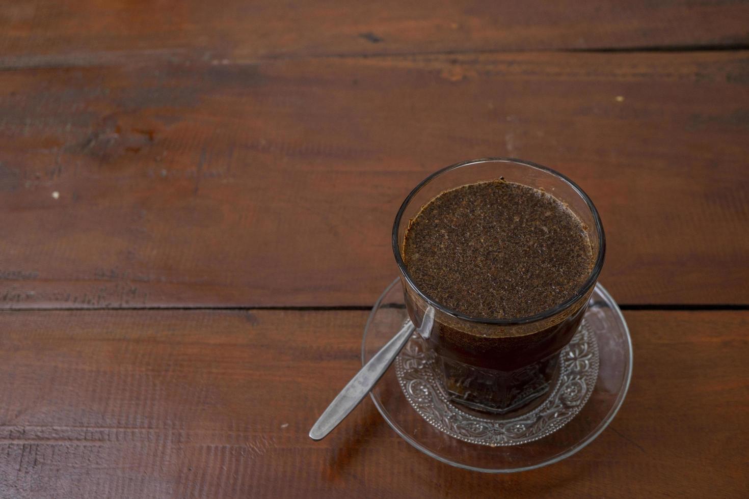 schließen oben Foto ein Tasse von Arabica Kaffee mit Löffel von hoch Winkel. das Foto ist geeignet zu verwenden zum Kaffee Geschäft Hintergrund, Speisekarte Poster und Kaffee Inhalt Medien.