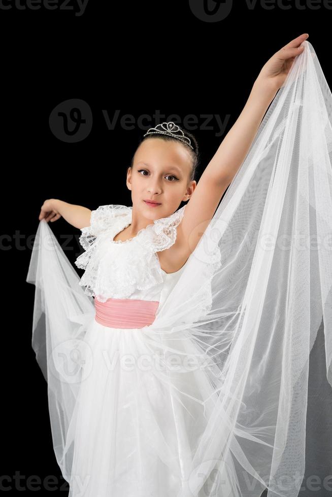 Mädchen Ballerina im Weiß lange Kleid Tanzen auf schwarz Hintergrund foto