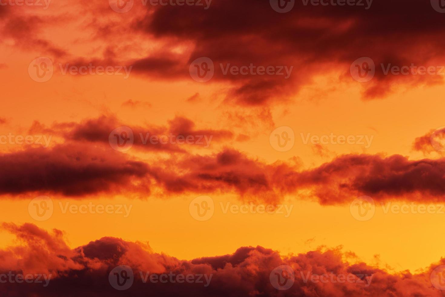 Orange Wolken glühend durch verschwinden Strahlen beim Sonnenuntergang schwebend über Gelb Himmel foto