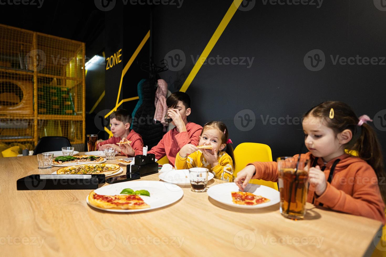 vier Kinder Essen Italienisch Pizza im Pizzeria. Kinder Essen beim Cafe. foto