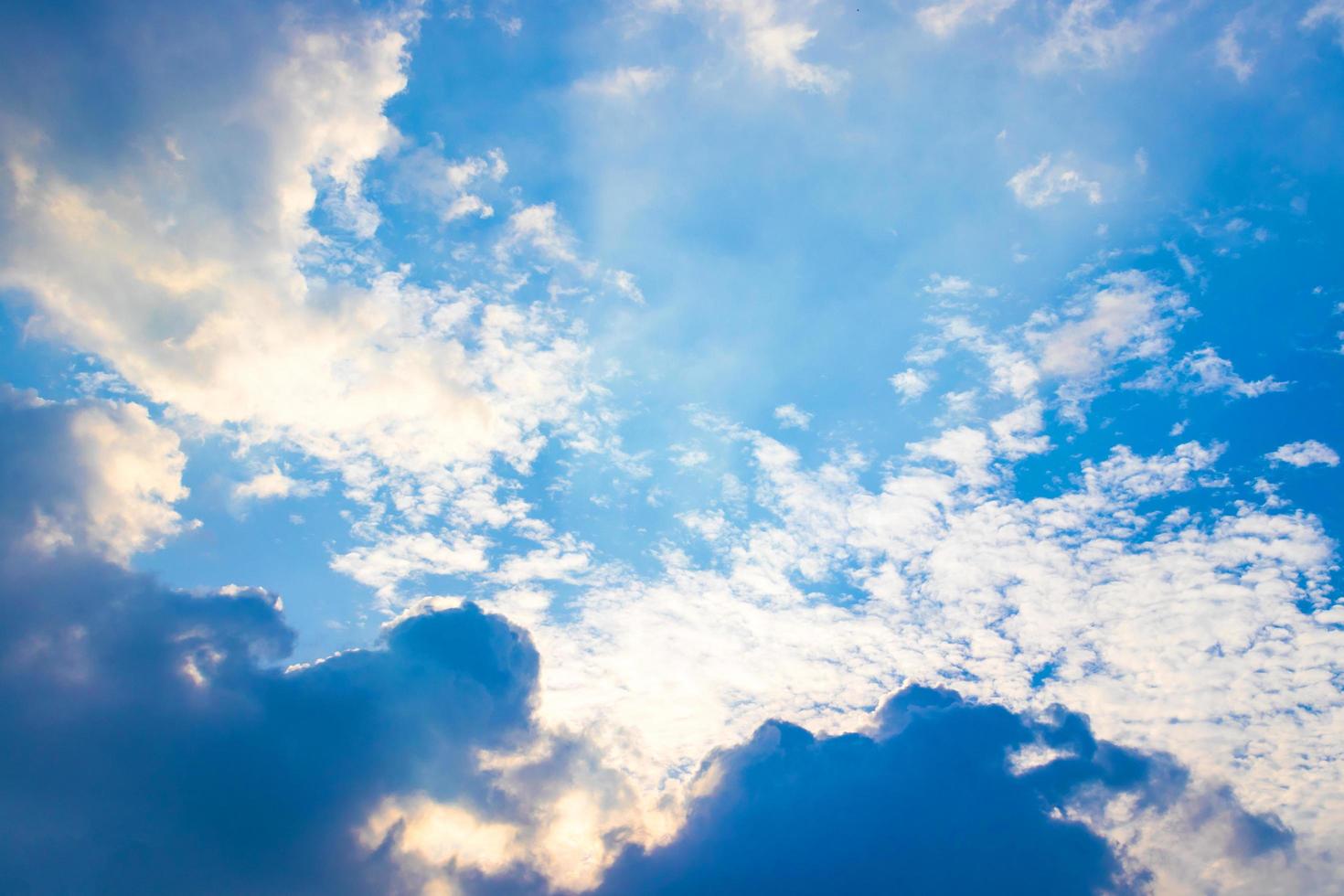 der Sonnenstrahl hinter den Wolken am blauen Himmel foto