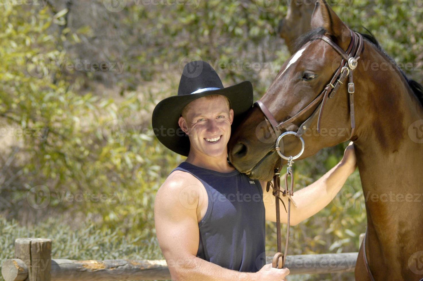 gut aussehend Cowboy haben ein Spaß Foto schießen mit seine Pferd.
