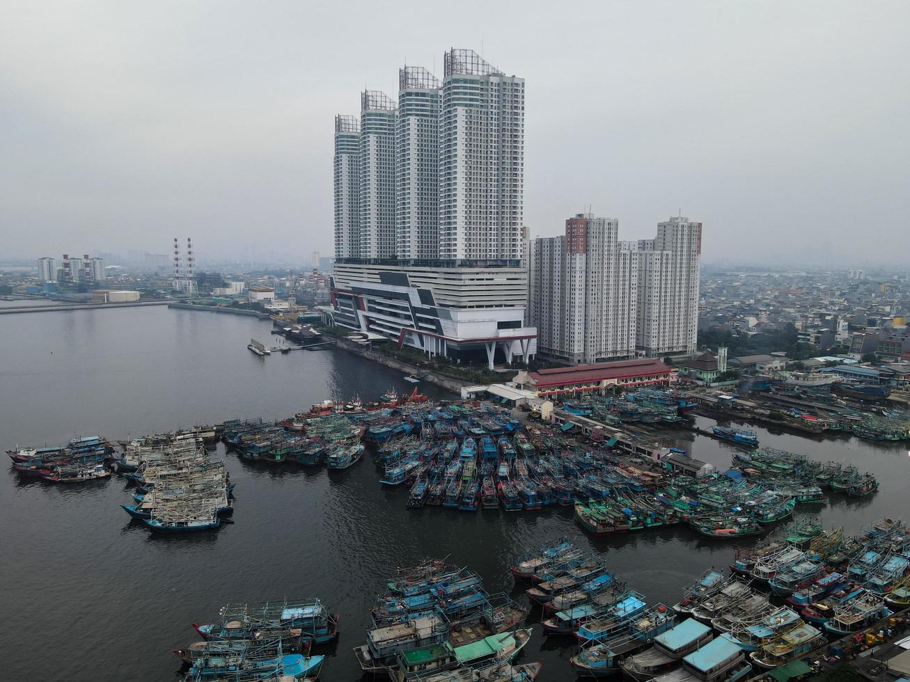 Jakarta, Indonesien 2021 - Luftdrohnenansicht des Muara-Angke-Strandes mit Holzbooten, die sich neben dem Pier lehnen foto