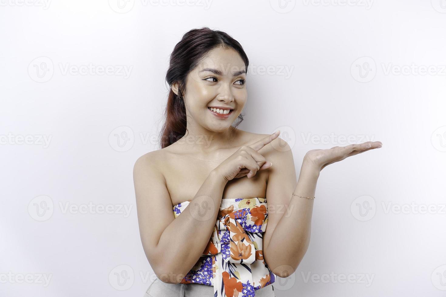 aufgeregt asiatisch Frau zeigen beim das Kopieren Raum neben ihr, isoliert durch Weiß Hintergrund foto
