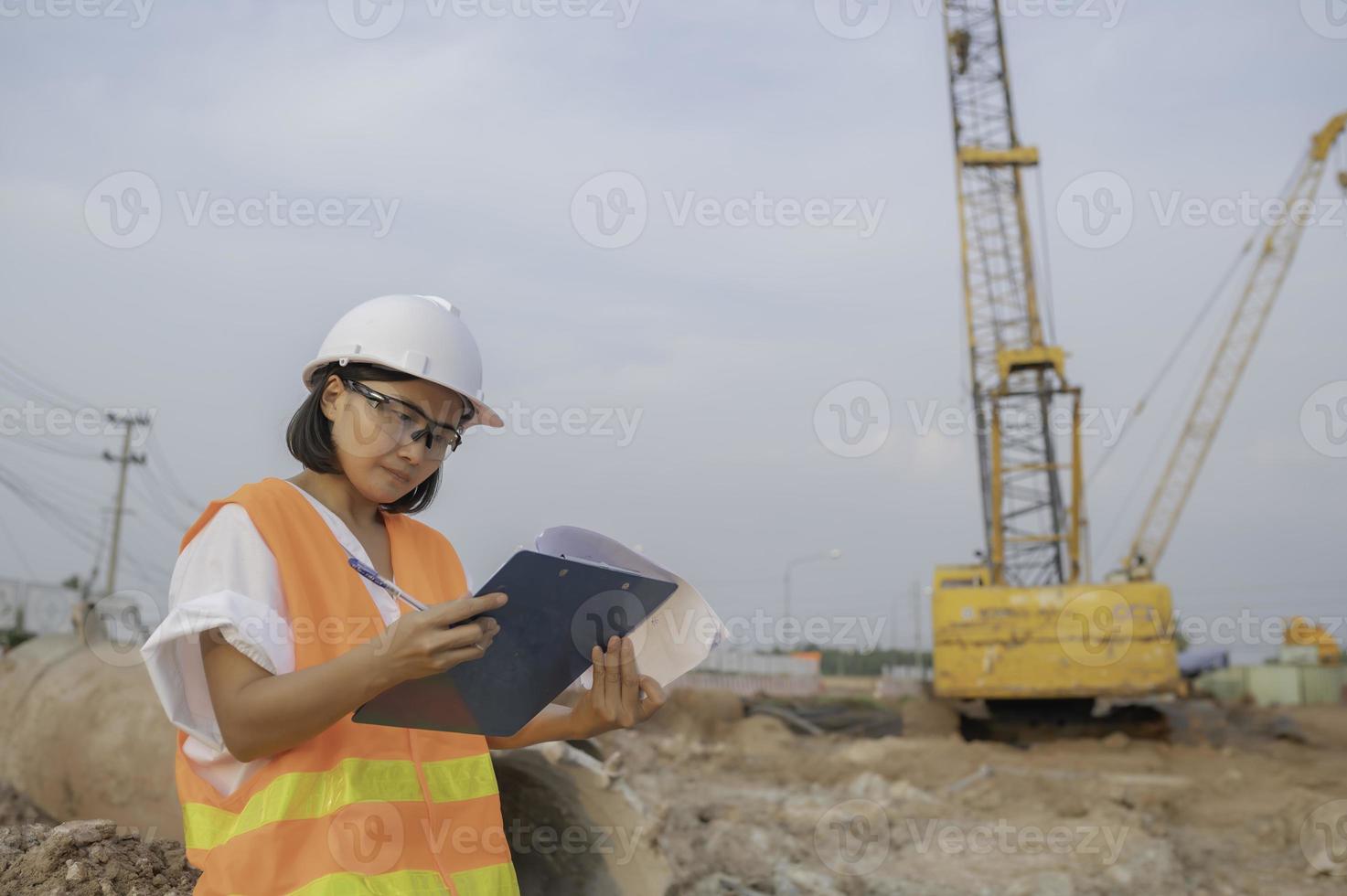 bürgerlich Ingenieure Arbeiten beim ein Konstruktion Website, die Unternehmen Manager überwacht das Straße Konstruktion. foto