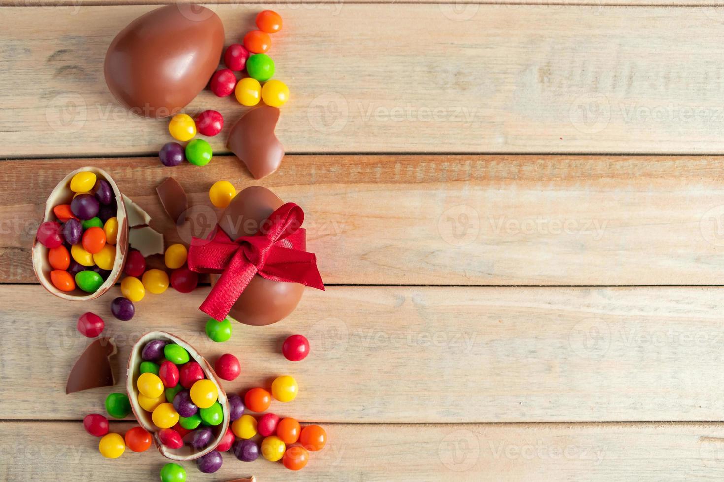 Schokoladeneier und Süßigkeiten auf einem braunen Hintergrund foto