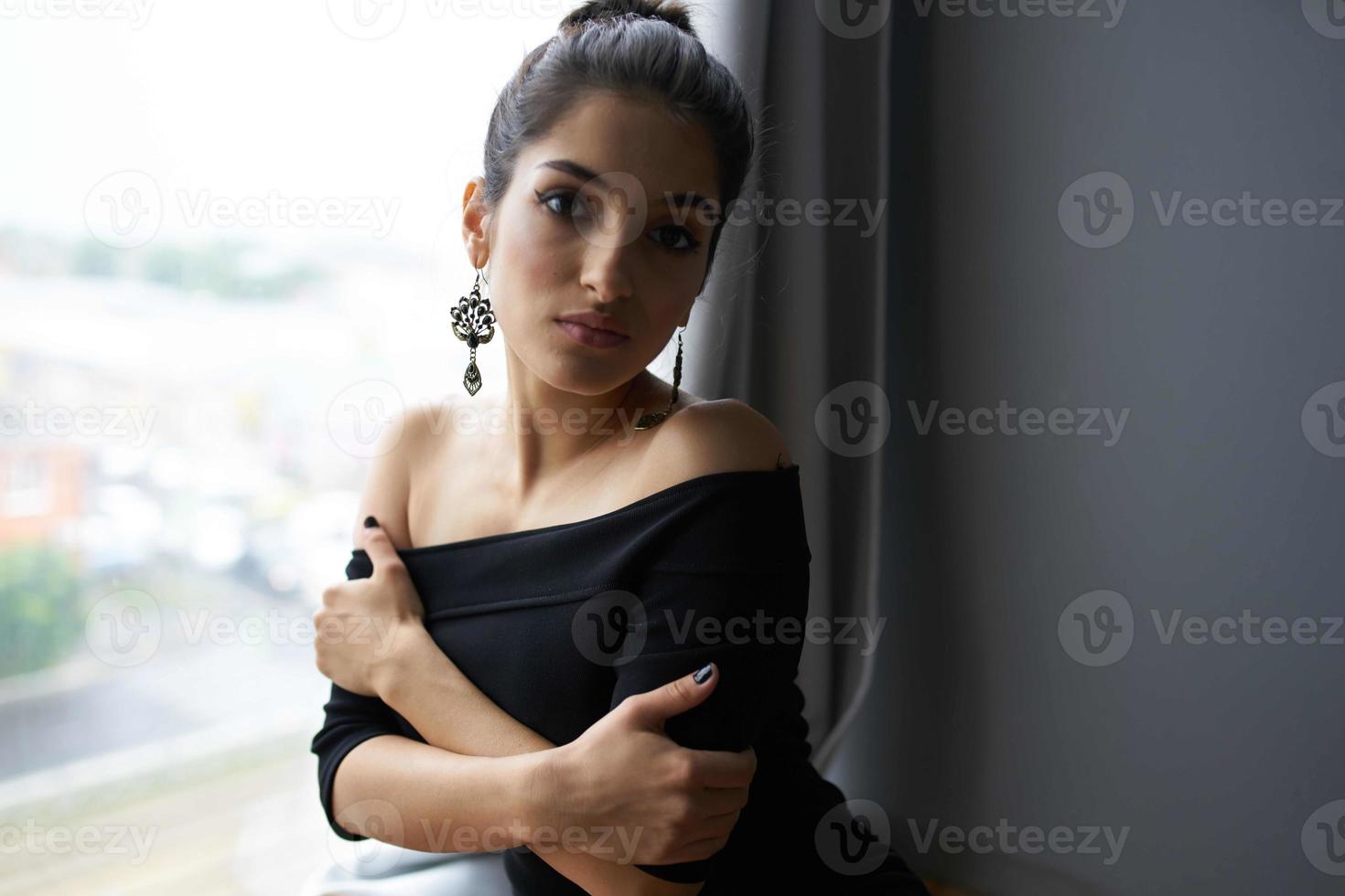 ziemlich Frau im ein schwarz Kleid in der Nähe von das Fenster posieren elegant Stil foto