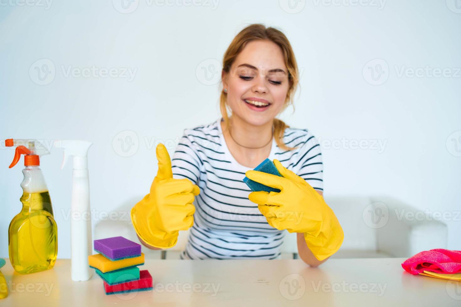 Reinigung Dame im Gummi Handschuhe sitzt beim das Tabelle Reinigung Werkzeuge Bedienung Lebensstil foto