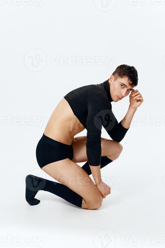 ein Mann im ein Sweatshirt und Socken und Unterhose kniet im voll Wachstum foto