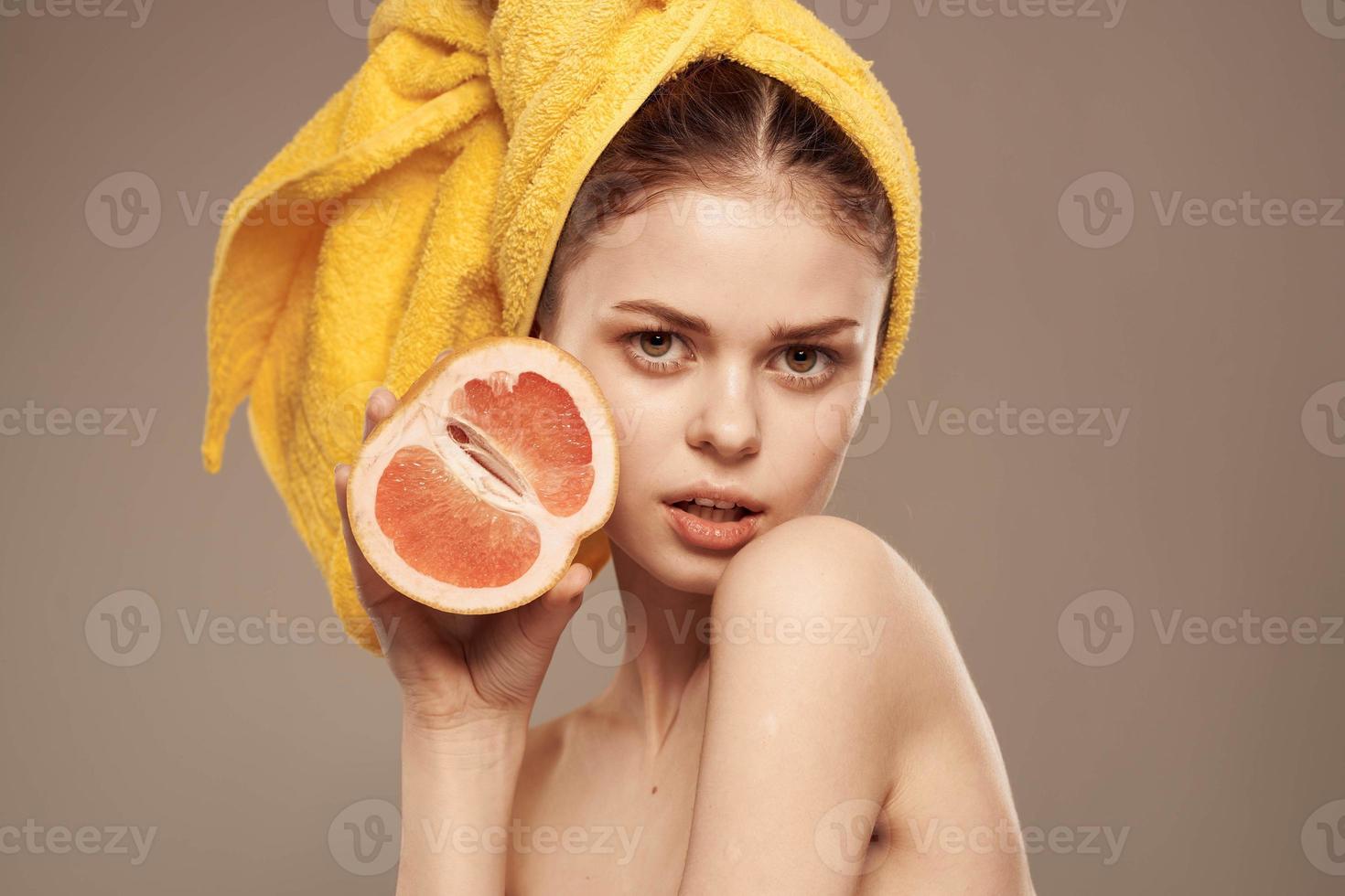 Frau mit ein Handtuch auf ihr Kopf Grapefruit im ihr Hände Gesundheit Vitamine entblößt Schultern foto