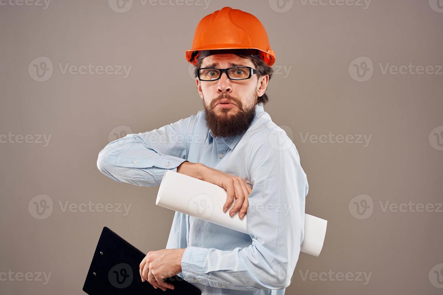 Ingenieur im ein Orange Helm Hemd Sicherheit Fachmann Bedienung Beige Hintergrund foto