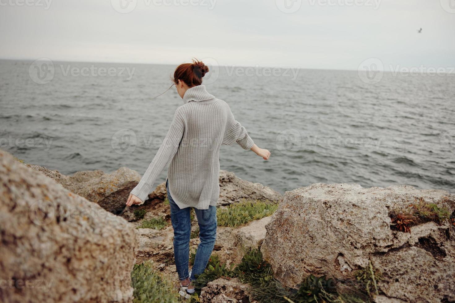 ziemlich Frau Pullover wolkig Meer bewundern Natur Lebensstil zurück Aussicht foto