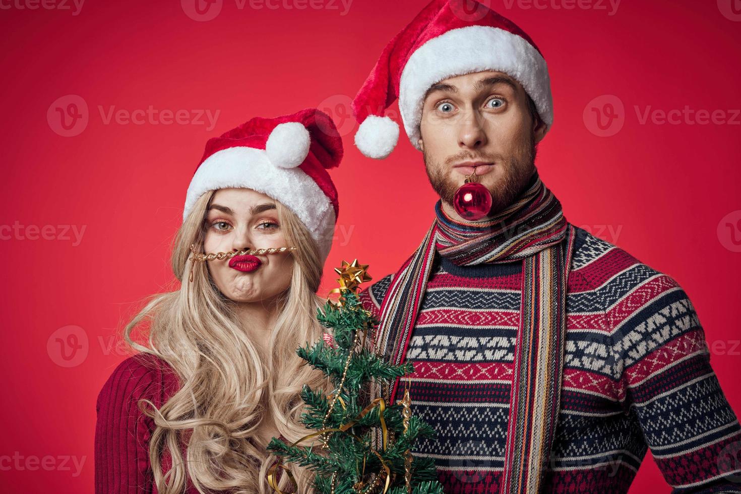 süß jung Paar halten Weihnachten Baum Spielzeuge Dekoration rot Hintergrund foto