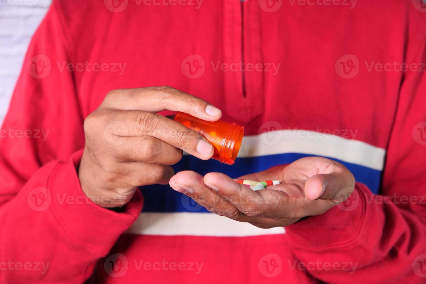 Nahaufnahme der Hand des Mannes, die Medizin nimmt foto