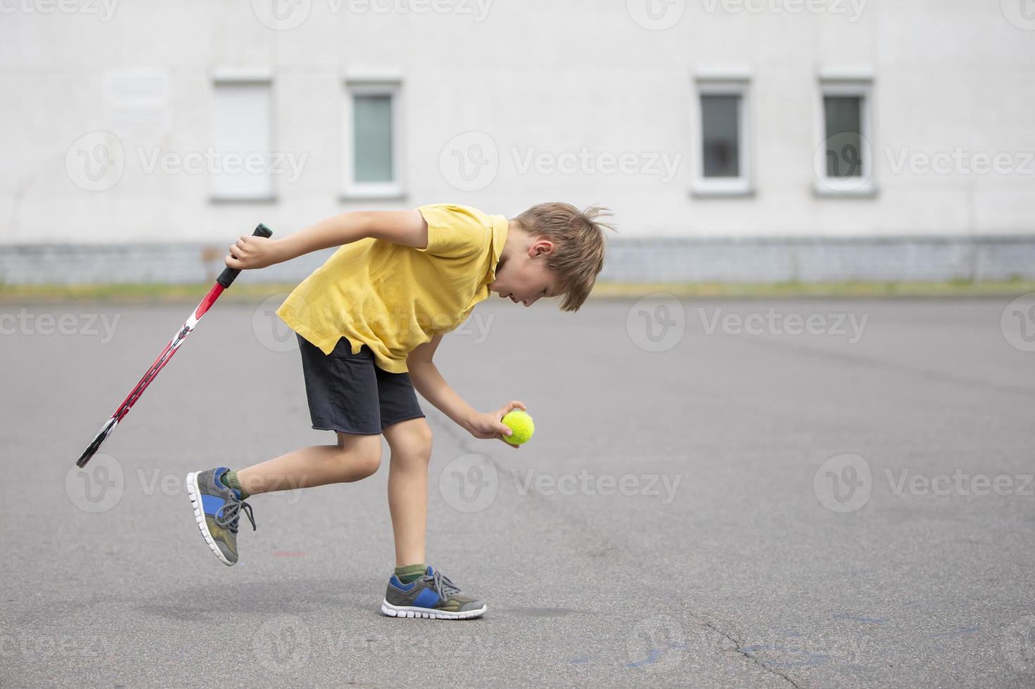 Kind mit ein Tennis Schläger und ein Ball. Junge Tennis Spieler. Schüler geht im zum Sport foto