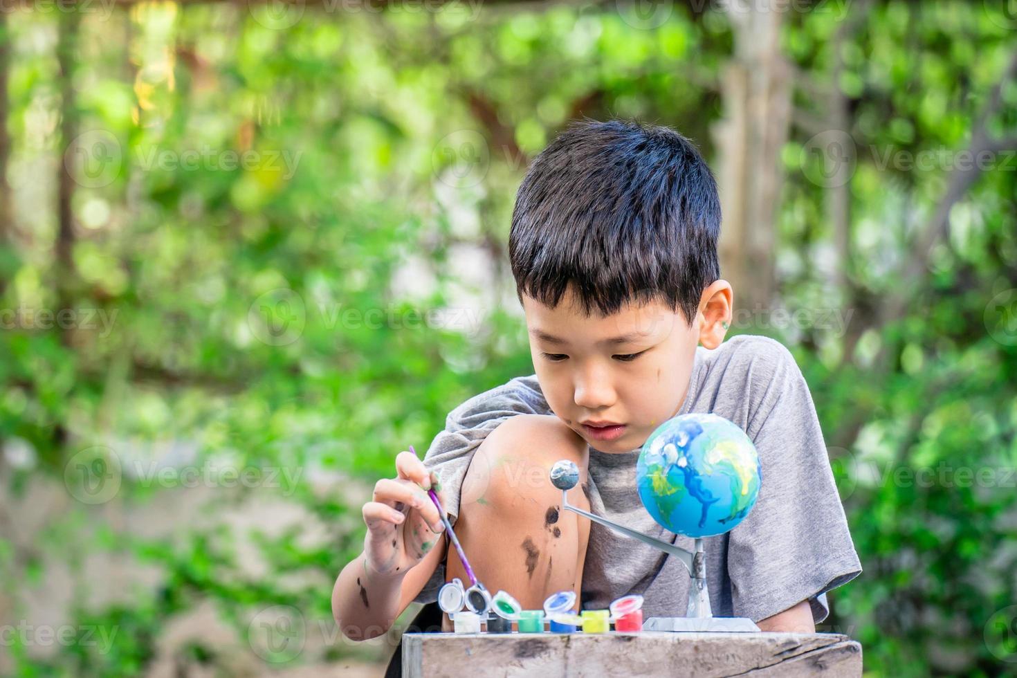 konzentriert asiatisch Junge Färbung Solar- System Spielzeuge, sensorisch Aktivität, Lernen Werkzeuge beim heim. foto