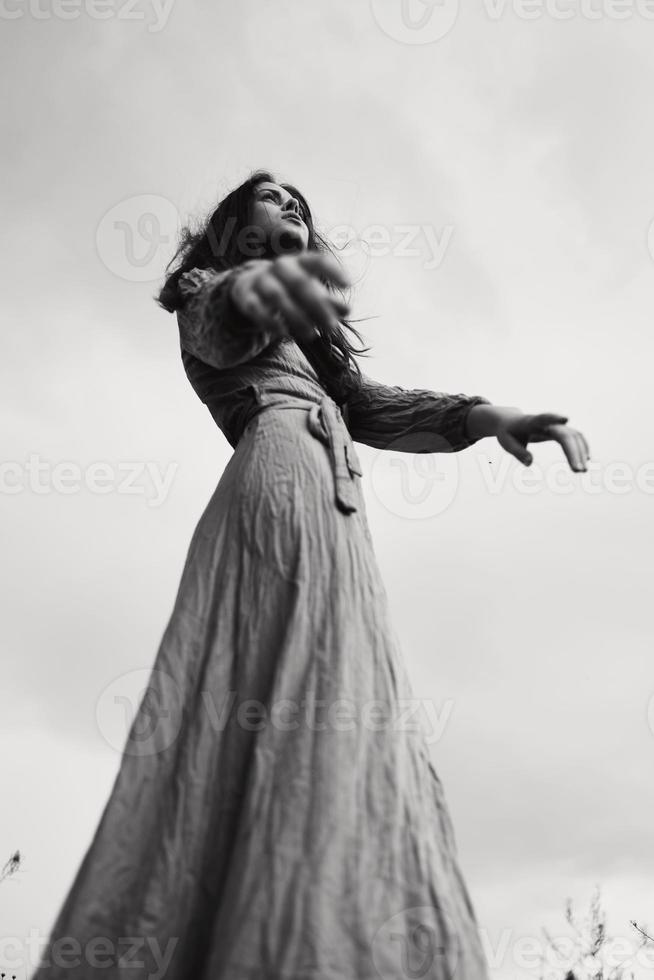 schön Frau im Kleid gestikulieren mit Hände posieren schwarz und Weiß Foto