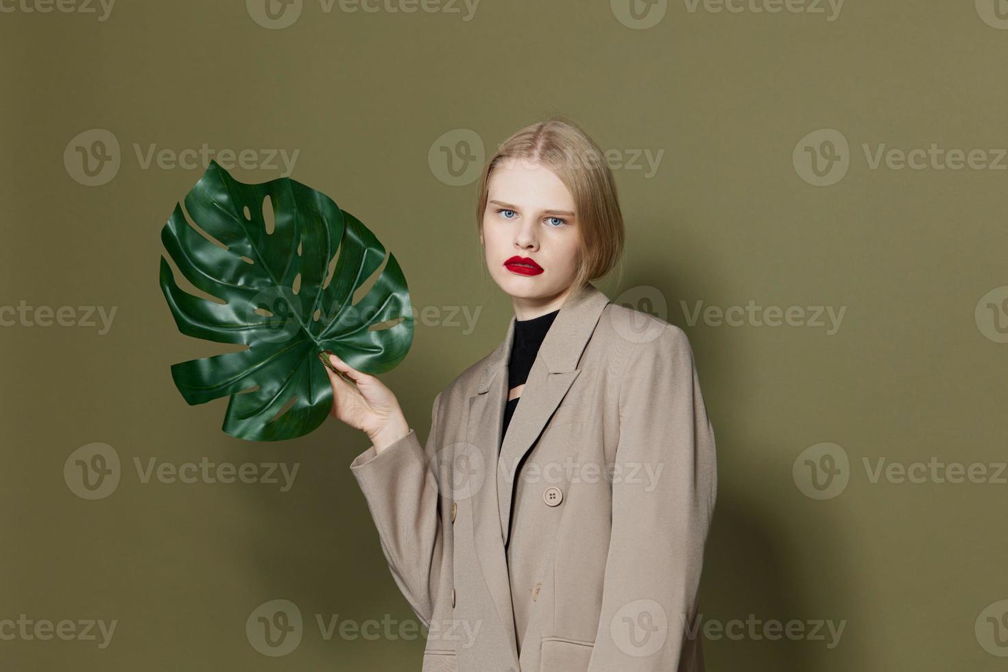 blond Frau im Mantel rot Lippen Mode Palme Blatt Lebensstil posieren foto