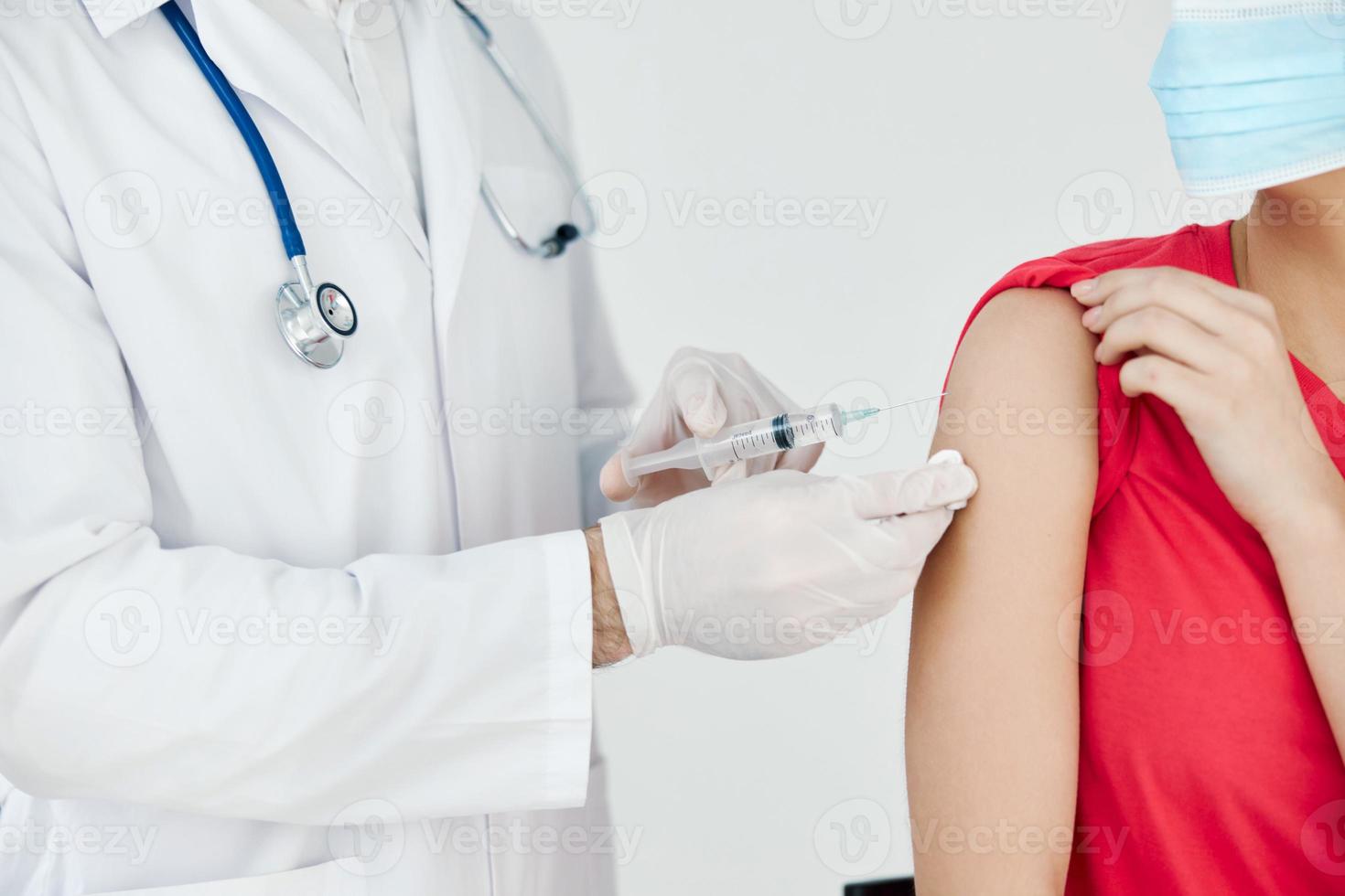 ein Arzt im ein Weiß Mantel Leckereien das Patienten Hand Vor Injektion covid Impfung foto