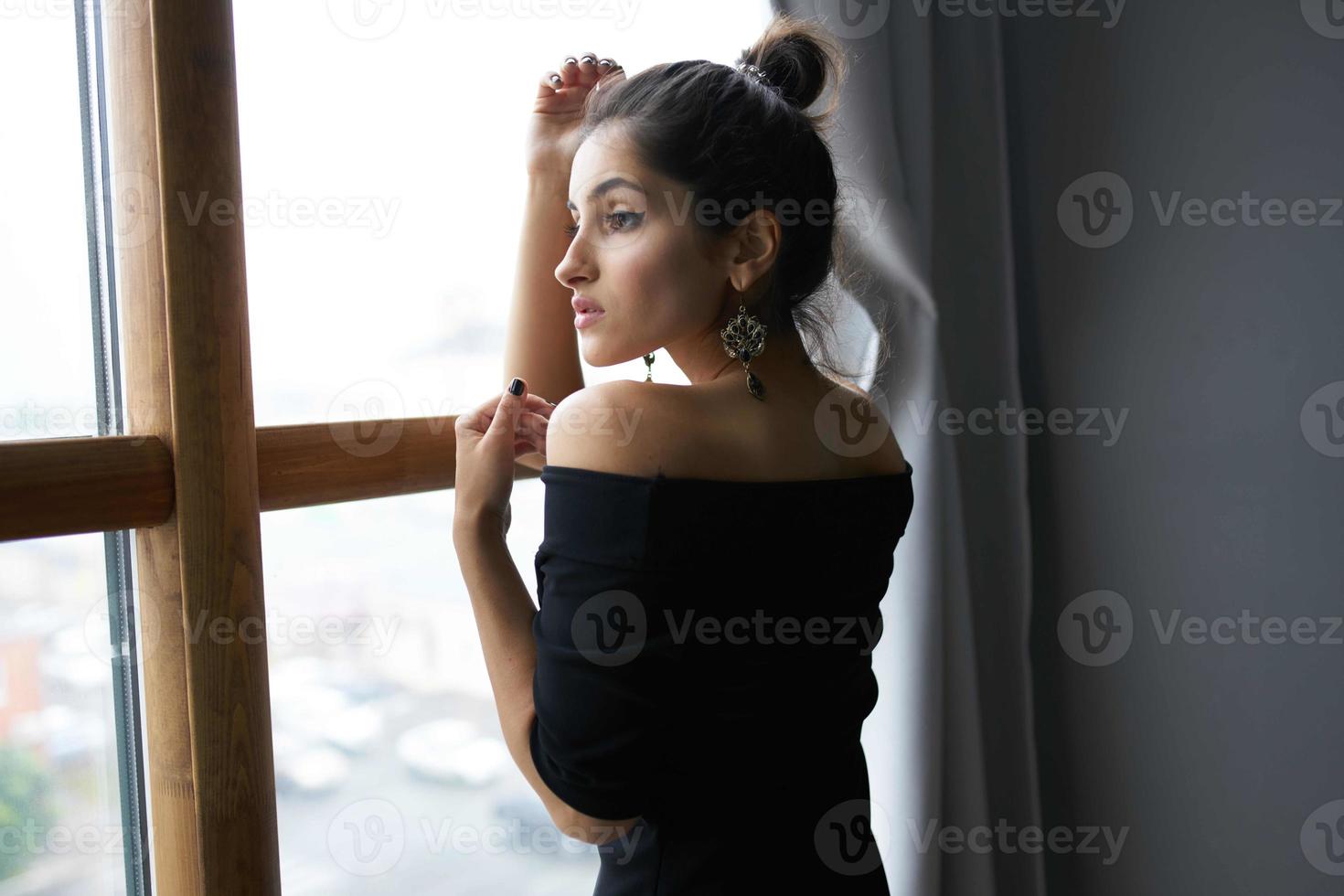 schön Frau in der Nähe von Fenster posieren attraktiv aussehen Ohrringe Mode Modell- foto