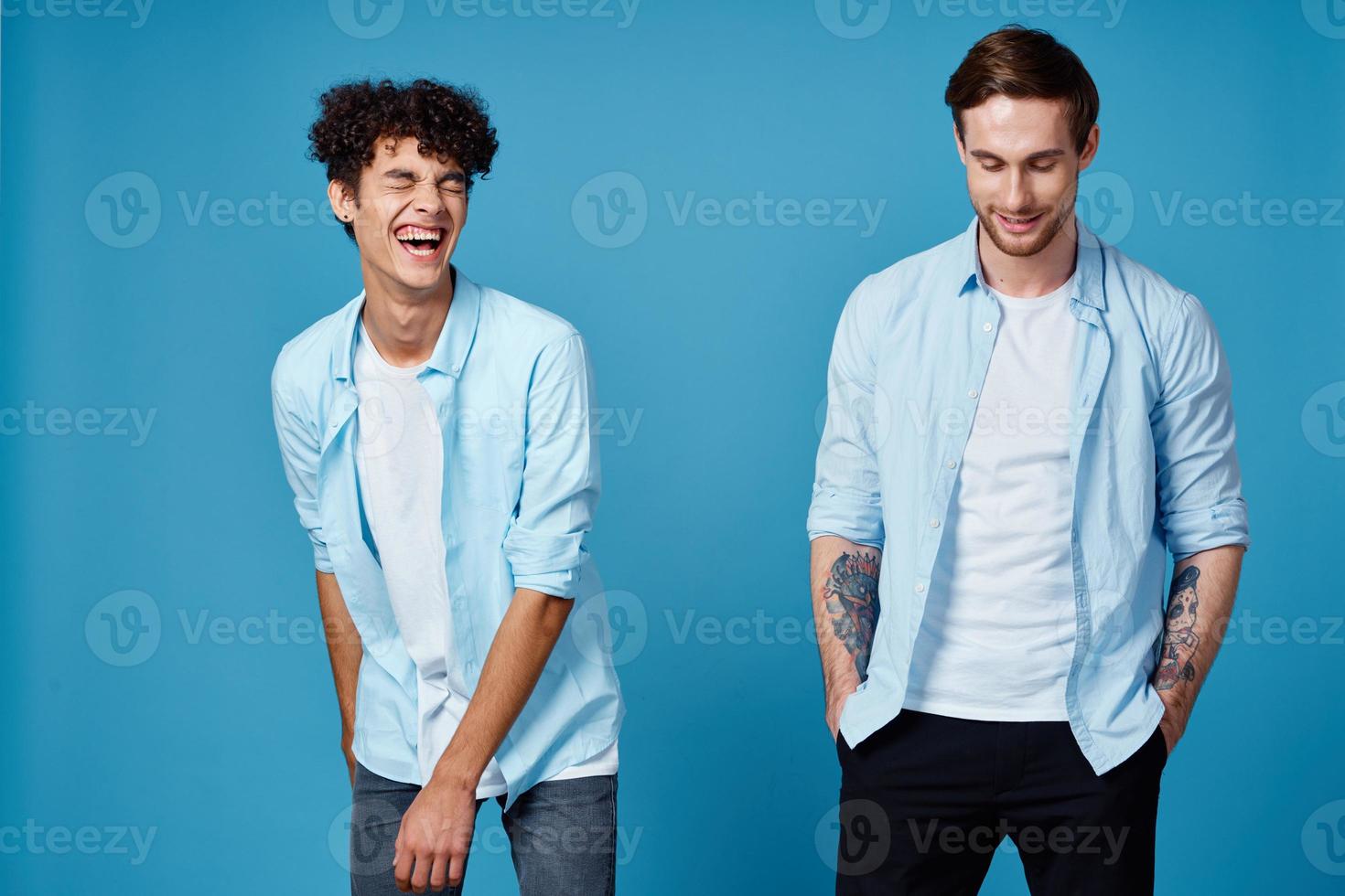 freunde im identisch Kleider auf Blau Hintergrund gestikulieren mit Hände abgeschnitten Aussicht foto
