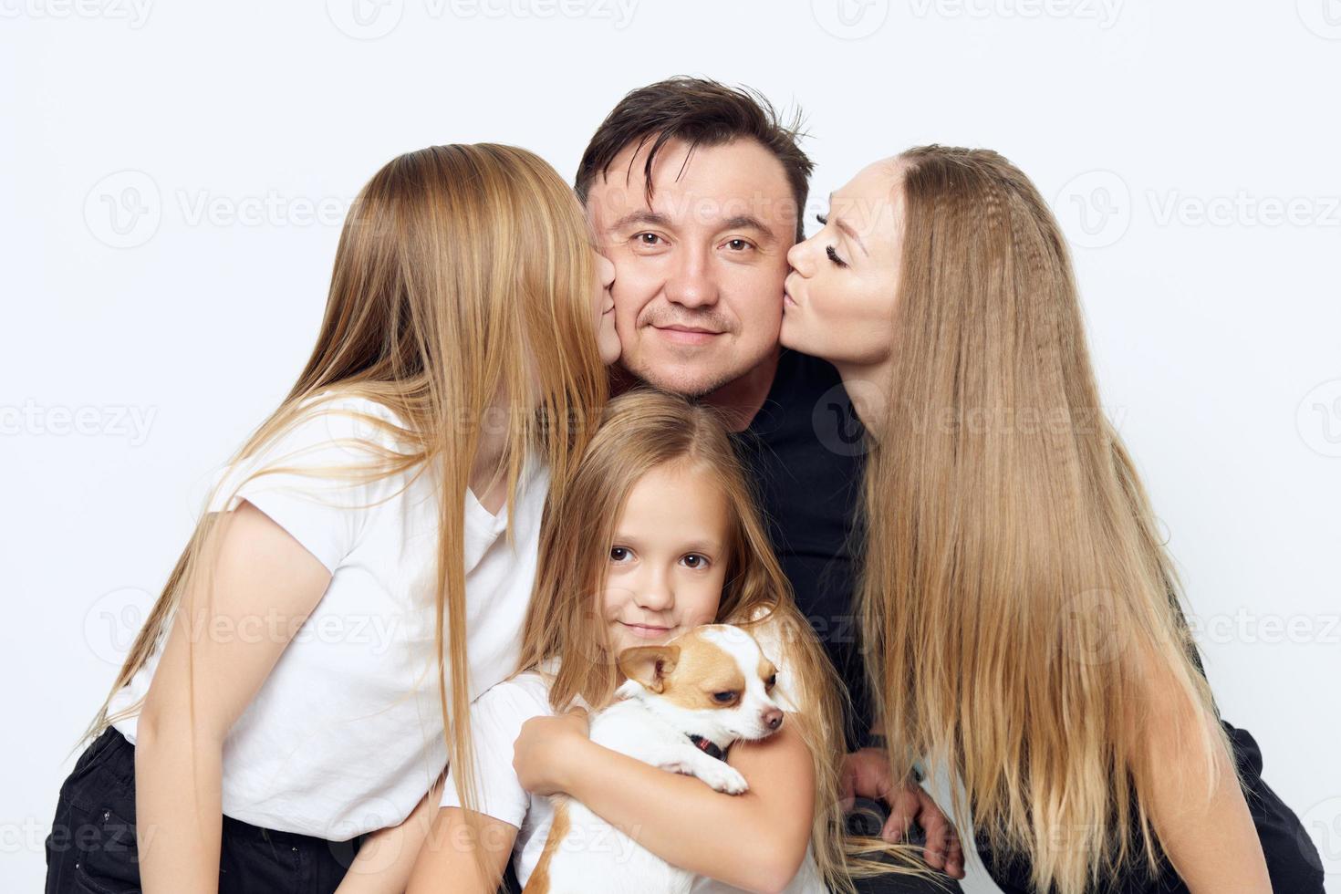 Mama mit Tochter küssen Vater Mädchen mit Hund im ihr Waffen Familie Foto Nahansicht