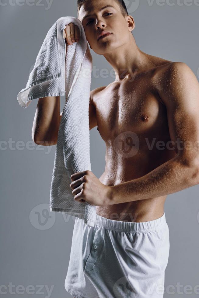 sportlich Kerl Weiß kurze Hose Bodybuilder trainieren Handtuch im Hand foto