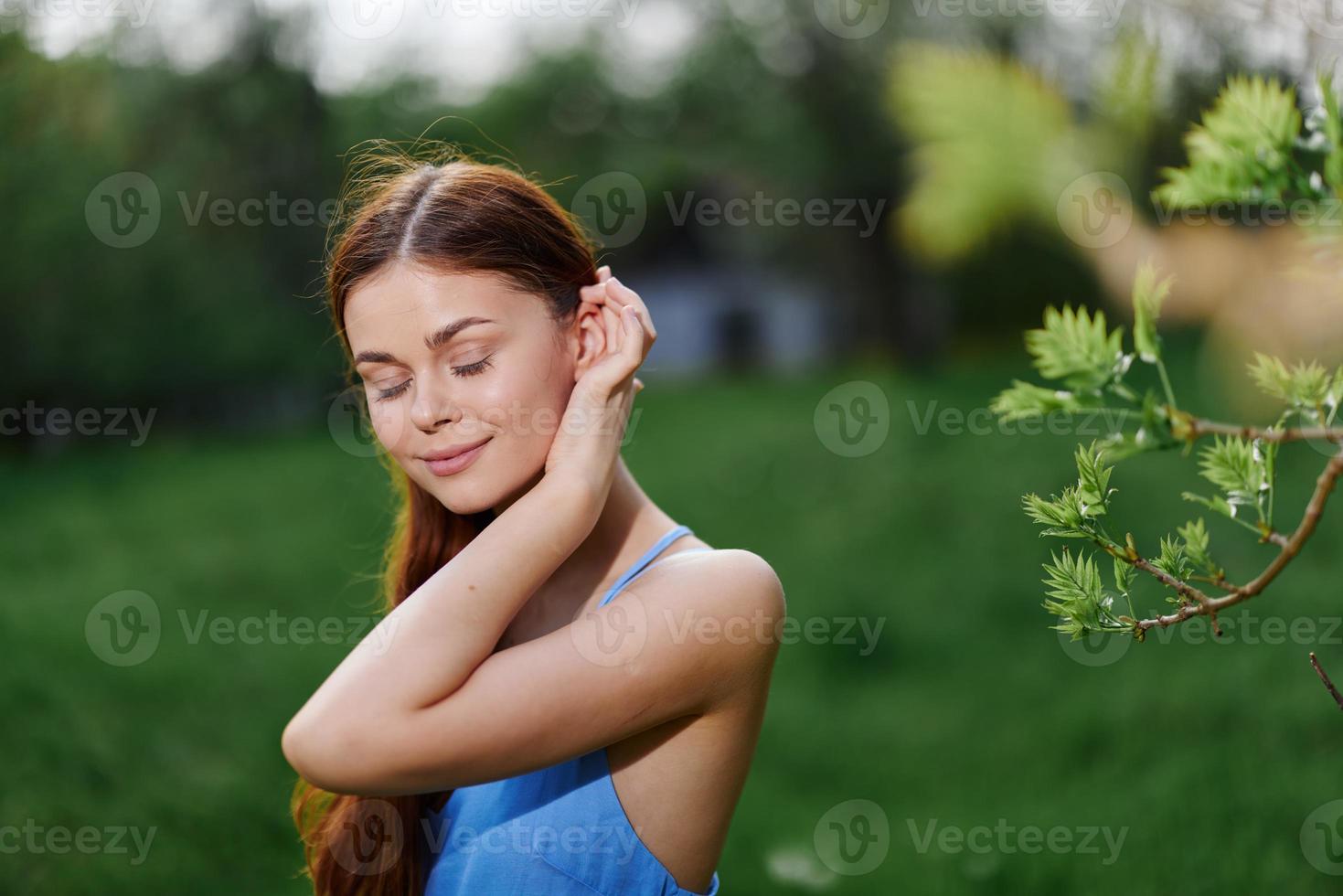 Porträt von ein jung Frau mit ein schön Lächeln mit Zähne im Natur auf das Hintergrund von Bäume im das Frühling auf ein sonnig Tag, das Schönheit von Gesundheit und Jugend, Glück, Freiheit foto