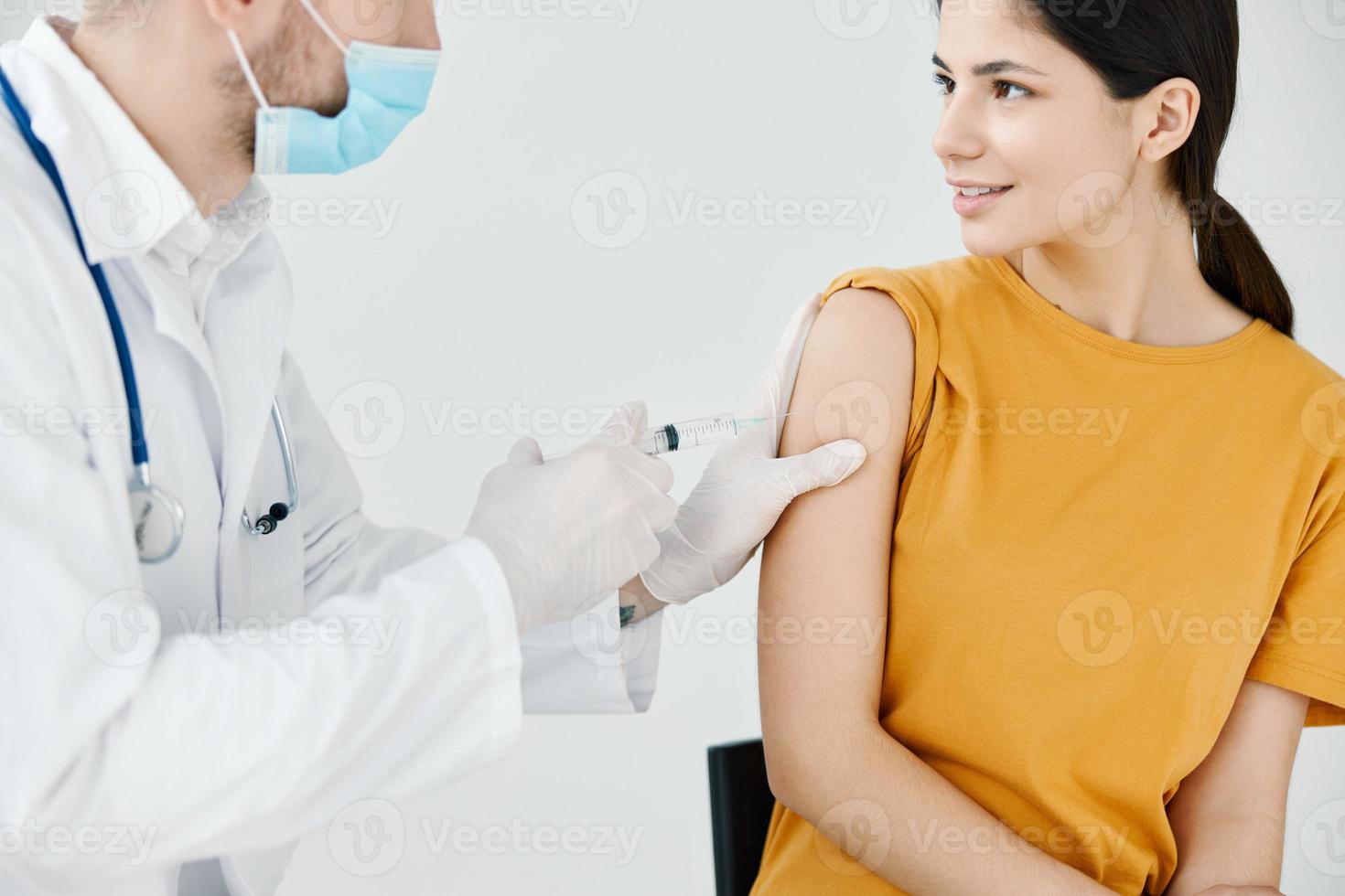 Arzt Bänder ein Schuss auf ein Frau Schulter im ein Krankenhaus Impfung foto