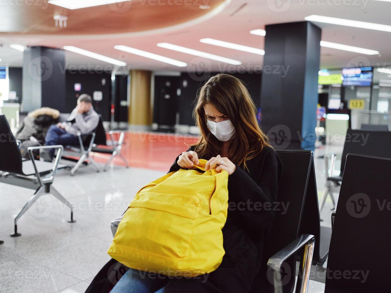 traurig Frau Sitzung beim das Flughafen mit Gepäck warten müde foto
