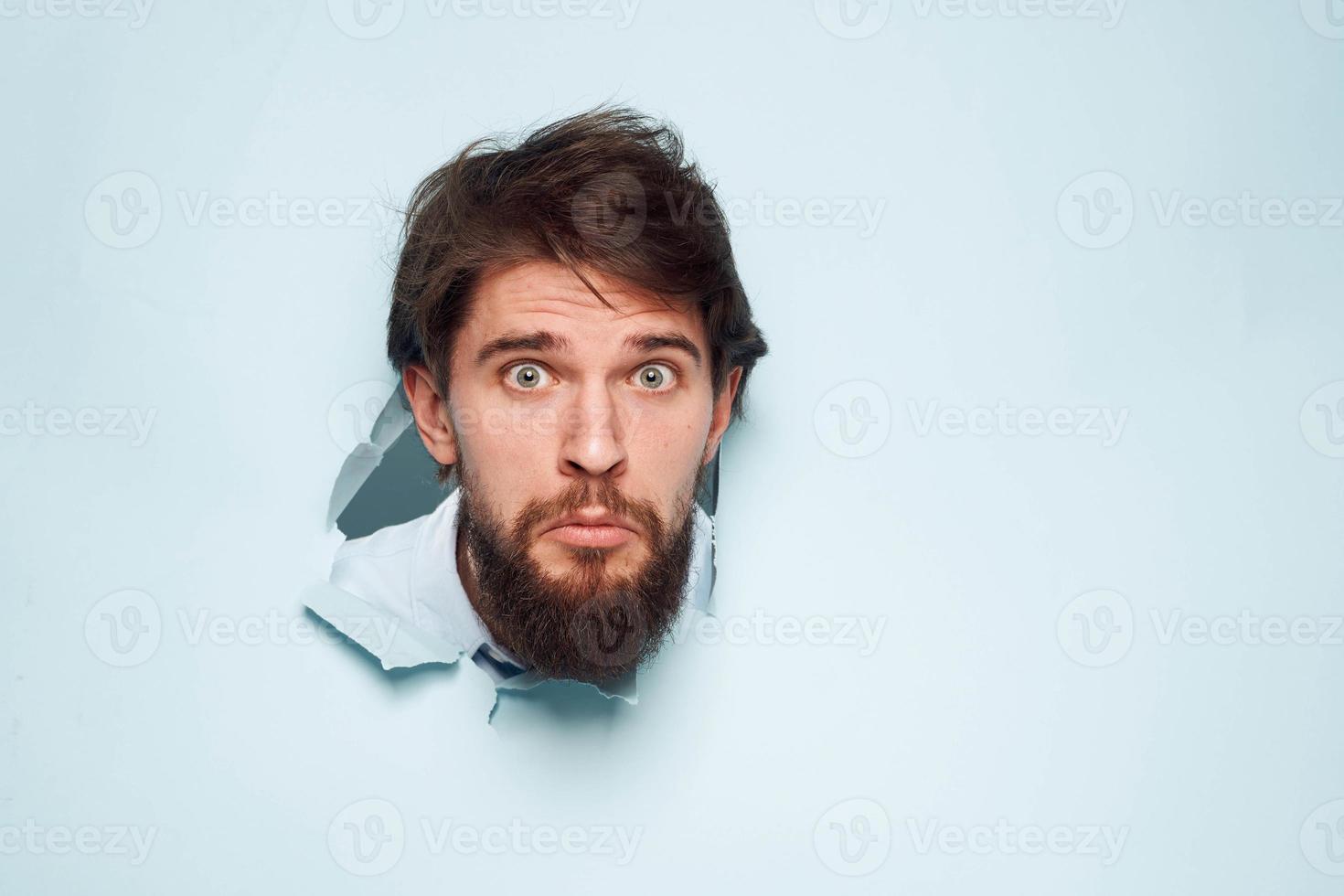 ein bärtig Mann guckt aus von hinter das Mauer Unzufriedenheit Emotionen Büro offiziell foto