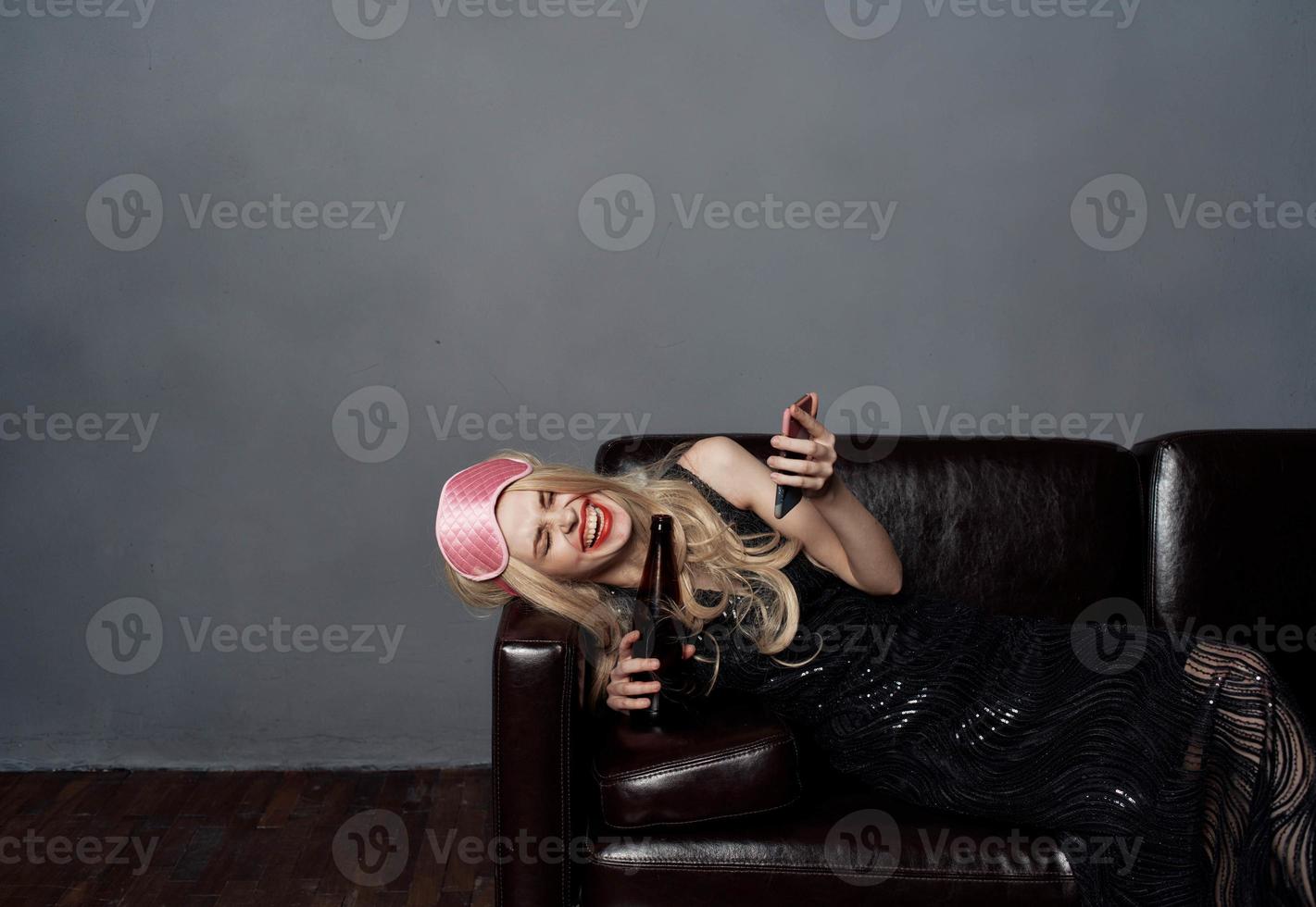 ein betrunken Frau auf das Couch ist nehmen Bilder von Sie selber auf ein Zelle Telefon foto