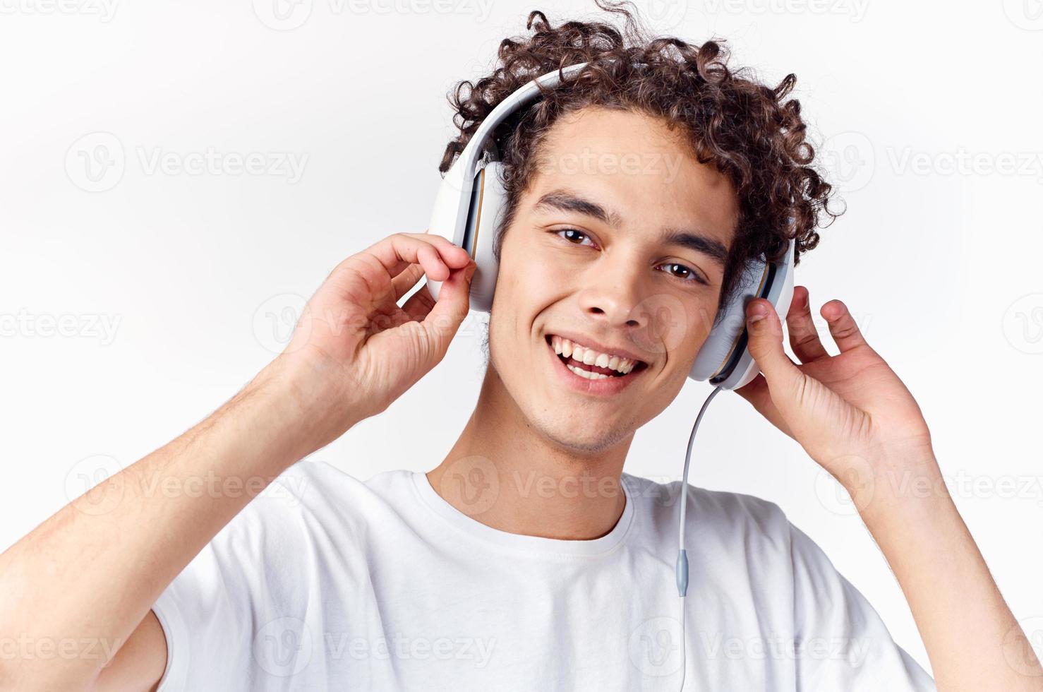 Mann mit lockig Haar und im Kopfhörer hört zu zu Musik- foto