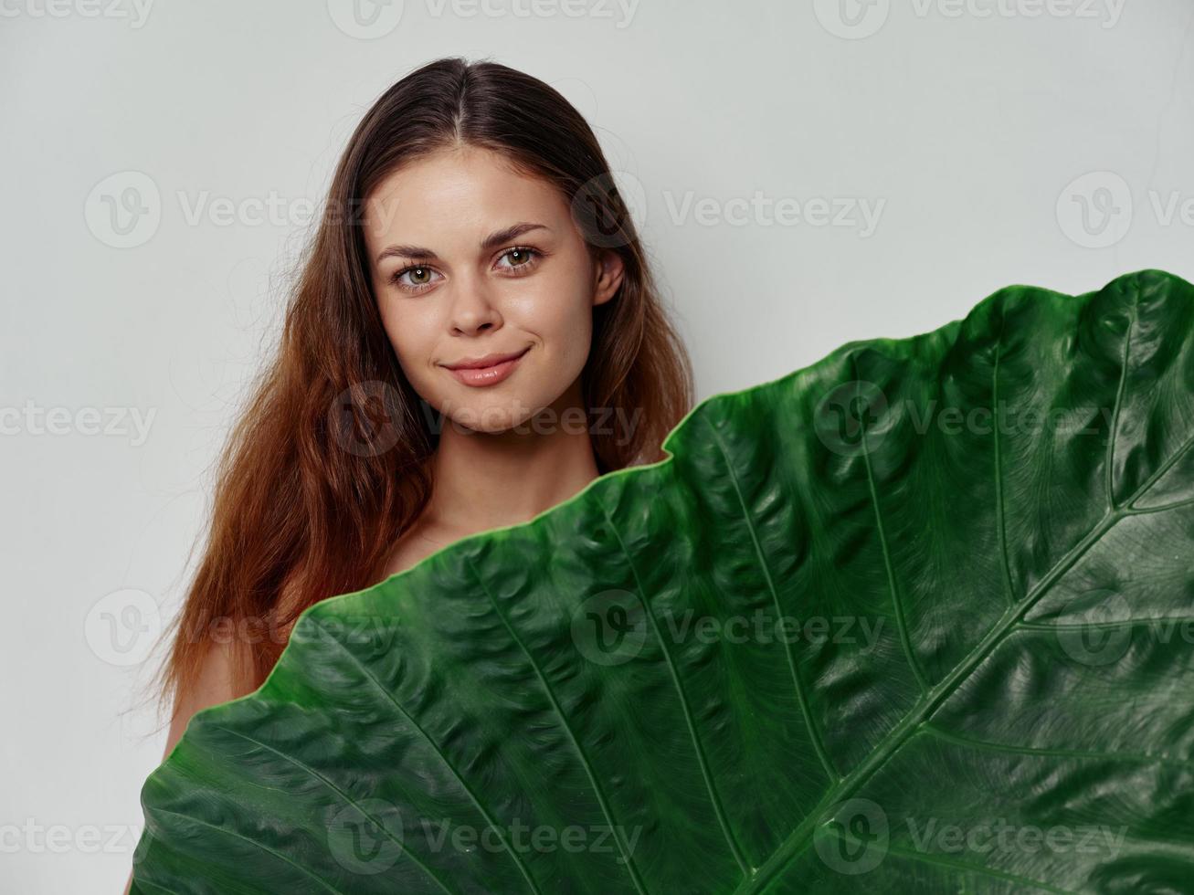 Frau mit Grün Blatt auf Licht Hintergrund sauber Haut Kosmetologie foto