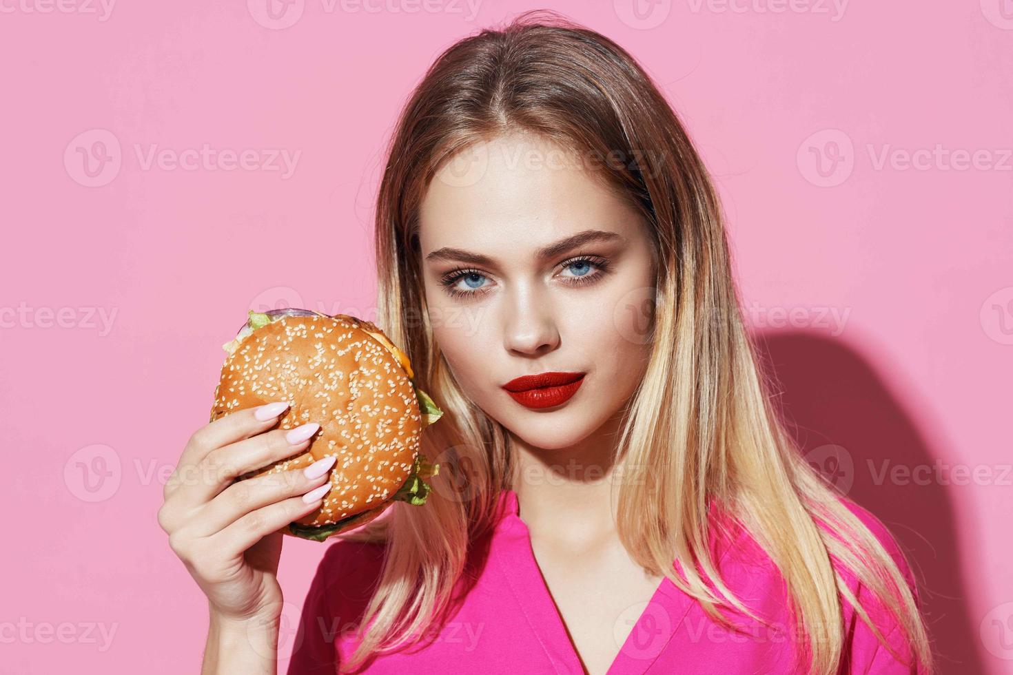 ziemlich Frau im Rosa Hemd mit Hamburger schnell Essen Diät foto